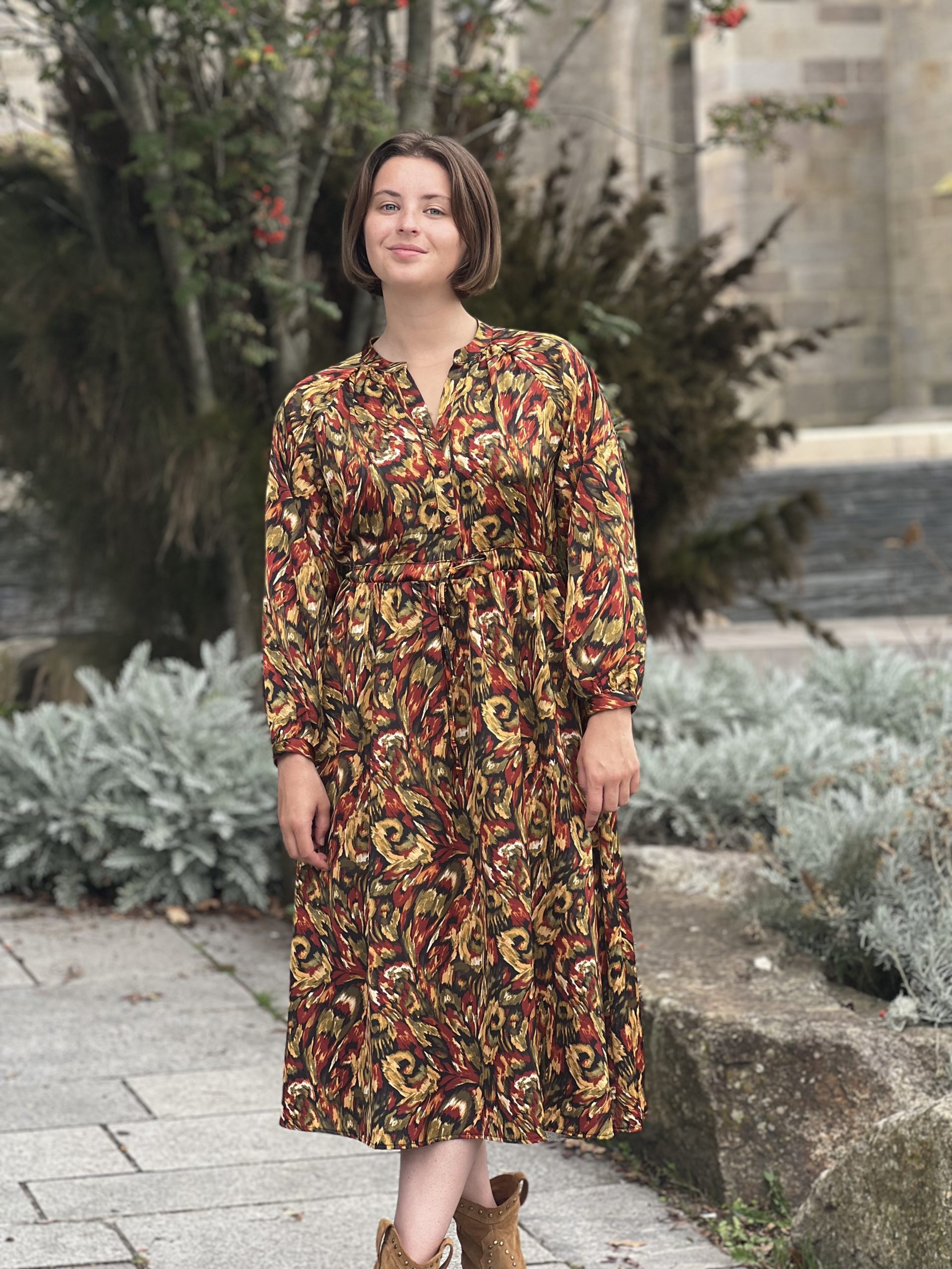 La robe Carla est mi longue avec un imprimé très automnale. Elle est fluide avec un col V boutonnée, manches longues et une ceinture coulissante à la taille. Elle est très stylée ! TU (du 34 au 42)