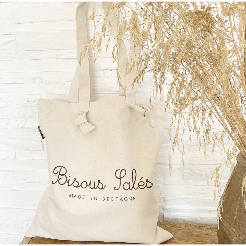 Notre Tote Bag "Bisous Salés"  made in Bretagne est tellement pratique et mignon qu'il vous accompagnera partout. Un indispensable pour transporter vos essentiels .  100% coton - dimension: 40X43 Grandes anses : 65 cm Il est  fabriqué en France