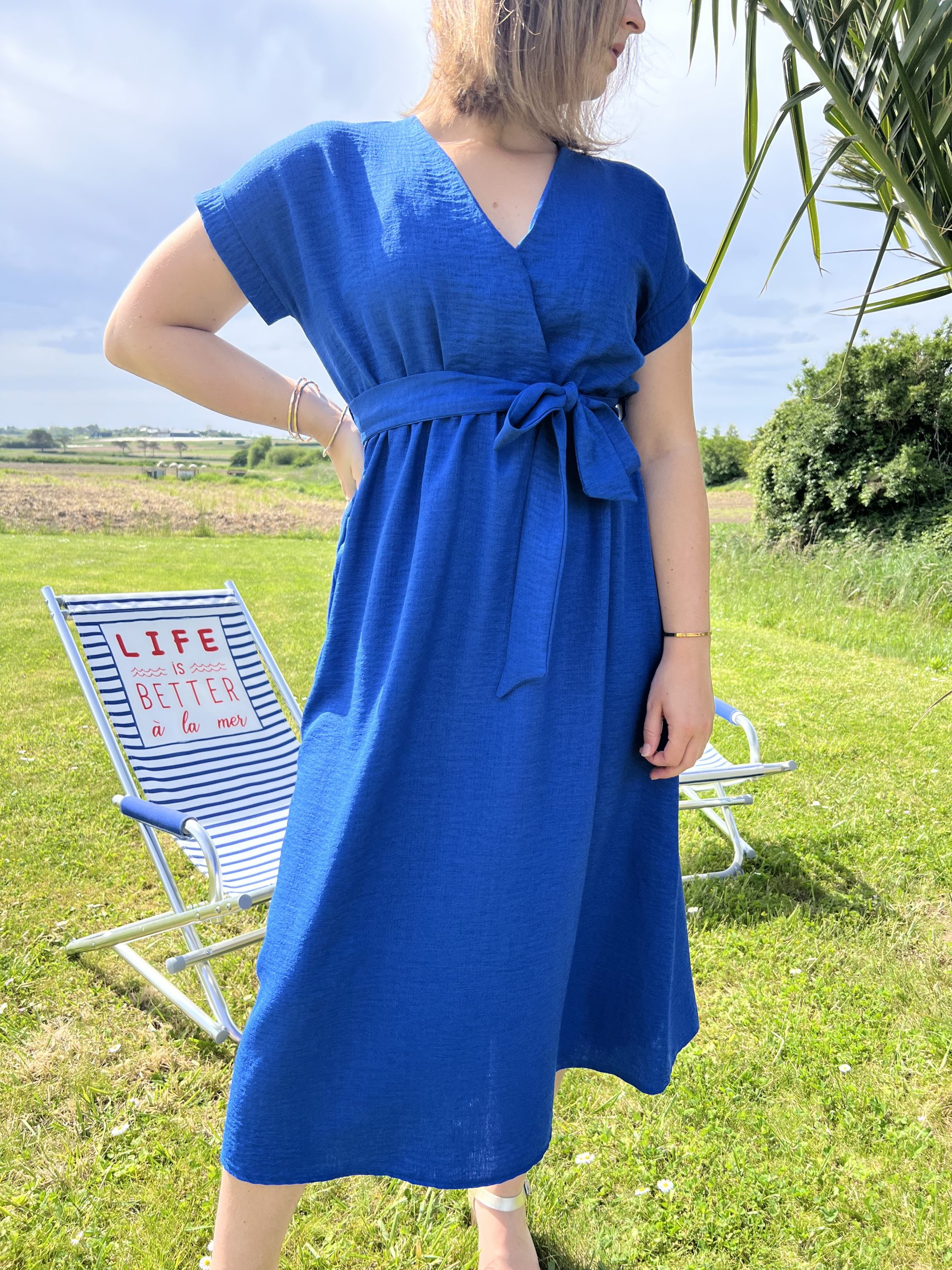 La robe Julia bleue est mi-longue, ses manches courtes effet papillon, sa taille élastiquée avec ceinture et son décolleté cache-cœur. Elle est subtilement féminine et vous sublimera au quotidien. Fabriquée en France