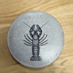 Apportez une touche d’originalité à votre table avec le sous-plat homard, une création en béton au design marin et graphique. Fabriqué en Bretagne