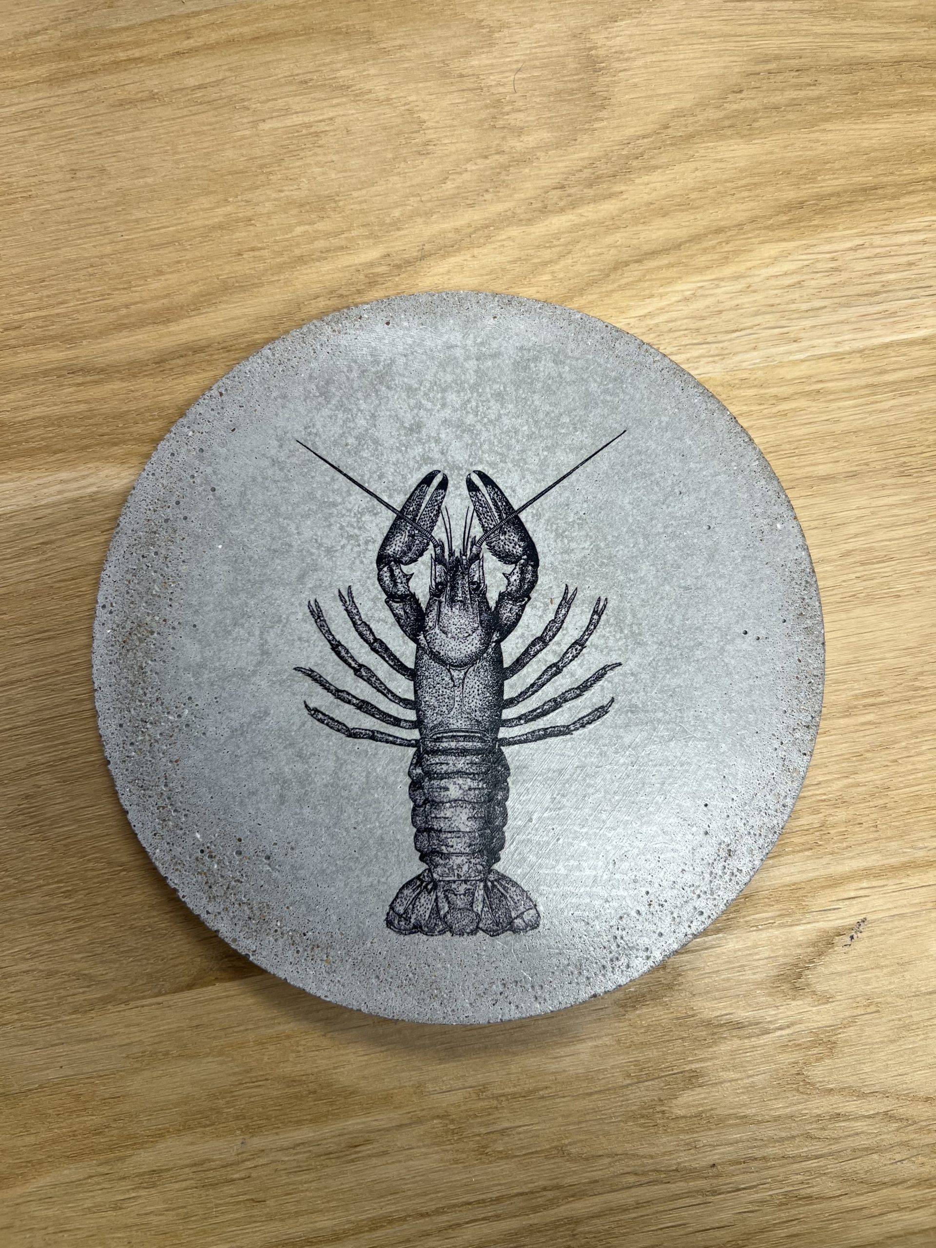 Apportez une touche d’originalité à votre table avec le sous-plat homard, une création en béton au design marin et graphique. Fabriqué en Bretagne